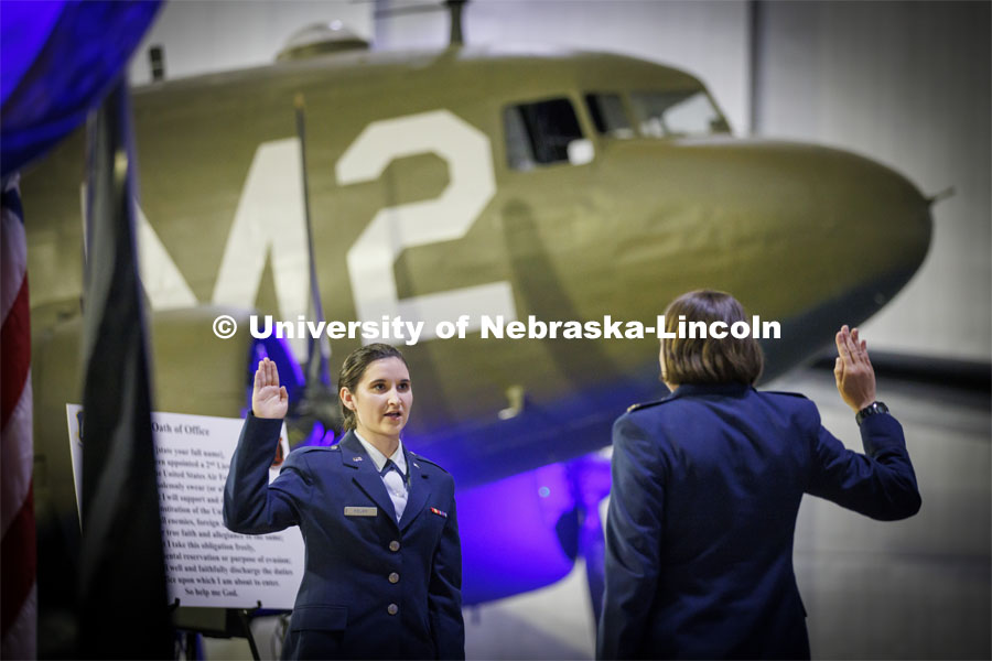 Second Lt. Isabel Welch recites the Oath of Office as directed by Air Force Major Nicole Beebe on May 16. The university’s Air Force ROTC detachment held a commissioning for May graduates at the Strategic Air Command and Aerospace Museum in Ashland. Welch will begin her service as a logistics readiness officer at Offutt Air Force Base in Omaha. In the background is a C-47 from World War II. May 16, 2022. Photo by Craig Chandler / University Communication.
