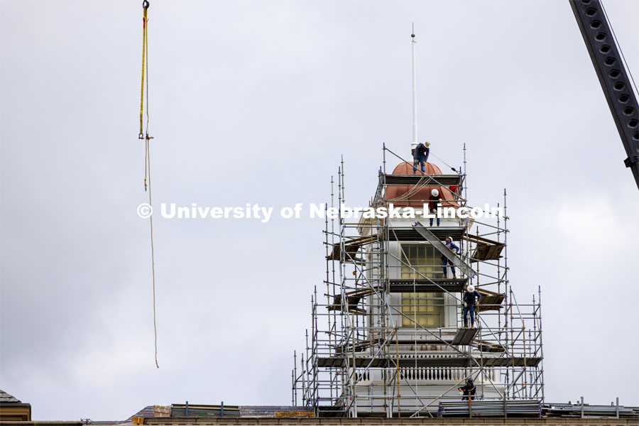 Walkway pieces are relayed into place as scaffolding work begins to surround the Love Library cupola as part of the renovation process. June 6, 2022. Photo by Craig Chandler / University Communication.