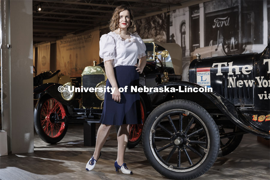 Channeling her everyday vintage inspired style, Anna Kuhlman wears this puff sleeve blouse designed by her based on late '30s and early '40s styles. Paired with navy pencil skirt and reproduction 30s shoes. She poses next to a 1924 Ford Model T at the Speedway Motors Museum of Speed. Kuhlman, who earned her master’s degree in May, researched fashion of the 1930s. June 7, 2022. Photo by Craig Chandler / University Communication.