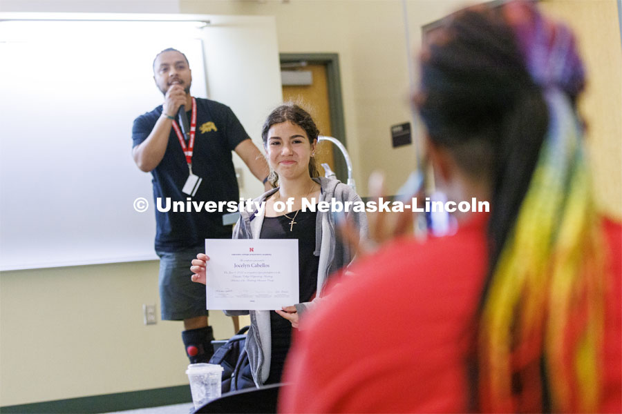 Jocelyn Cabellos, a frehsman at Omaha South, holds up her certificate for a photo as David Orozco-Garcia, a NCPA counselor for Omaha South calls up the next student. NCPA freshman and sophomore high school students on campus. June 8, 2022. Photo by Craig Chandler / University Communication.