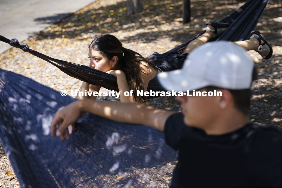 Karla Zavala and Matthew Klein, both from Fremont, hang out in the hammocks outside the Nebraska Union. Klein is a senior at UNL and Zavala is a grad student at UNO. June 16, 2022. Photo by Craig Chandler / University Communication.