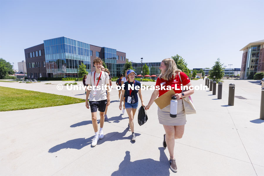 Shaeley Wiese, New Student Orientation Leader, talks with students as they leave Cather Dining Center for a tour of campus. NSE Leaders walking on campus with their student groups. June 16, 2022. Photo by Craig Chandler / University Communication.