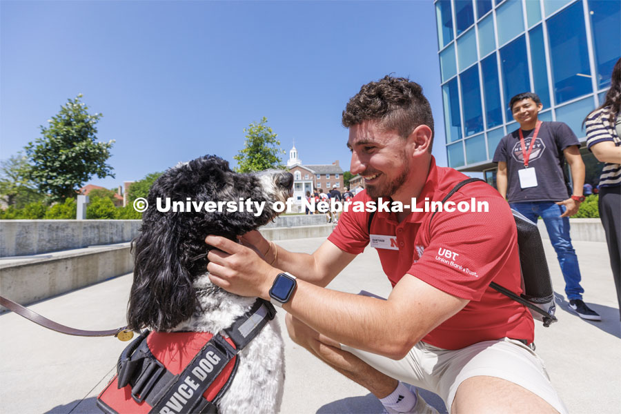 Hershey receives plenty of attention from NSE students outside the Cather Dining Center. Hershey is a 1 1/2 year old labradoodle being trained as a therapy dog. He will be part of the UNL Police Department this fall. June 17, 2022. Photo by Craig Chandler / University Communication.