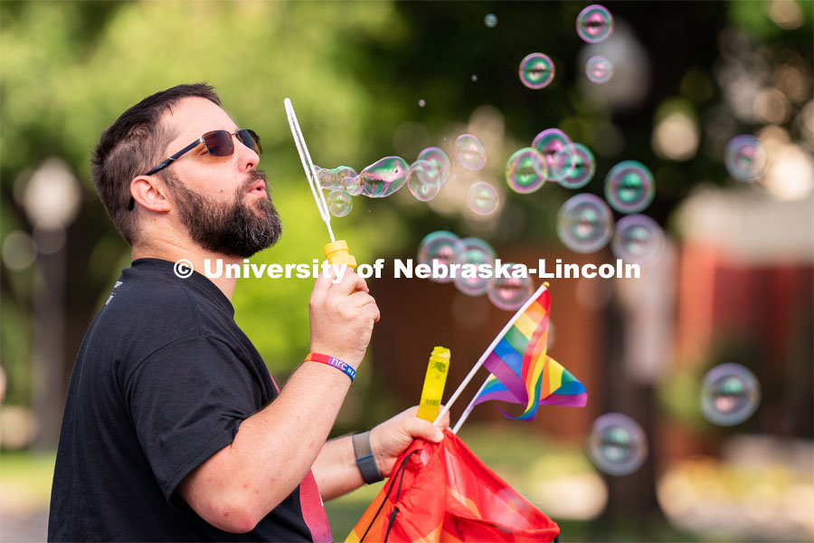 A parade-goer blows bubbles as they walk around the Lincoln Capitol Building during the Star City Pride parade. June 18, 2022. Photo by Jordan Opp for University Communication.