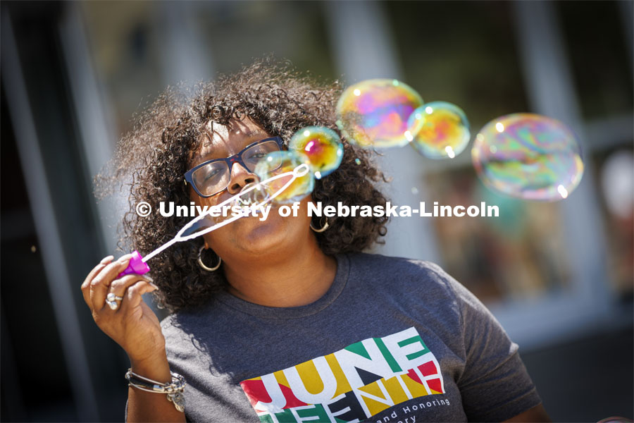 Charlie Foster, Assistant Vice Chancellor for Inclusive Student Excellence and Director of the Office of Academic Success and Intercultural Services, blows a series of bubbles across the Nebraska Union Plaza during the university’s inaugural celebration of Juneteenth. Juneteenth, the federal holiday that commemorates the emancipation of enslaved Black Americans, is celebrated in an event starting at noon on the Nebraska Union Plaza. June 20, 2022. Photo by Craig Chandler / University Communication.