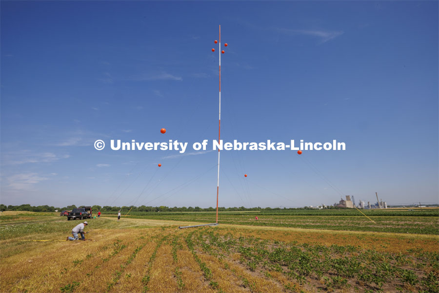 A tower goes up at the UNL 84th and Havelock fields for Benjamin Riggan, assistant professor of electrical and computer engineering. He is part of a team of researchers from across the country participating in a federal government research program to develop software systems capable of performing whole-body biometric identification from long distances and at elevated pitch. June 27, 2022.  Photo by Craig Chandler / University Communication.