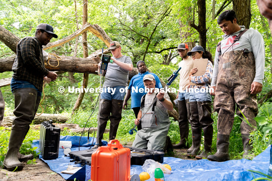 Research Engineer Alan Boldt (center-right) assembles tools to measure the water flow rates of Salt Creek at Wilderness Park. Irrigation Laboratory and Field Course class trip to Salt Creek at Wilderness Park. July 8, 2022. Photo by Jordan Opp for University Communication.