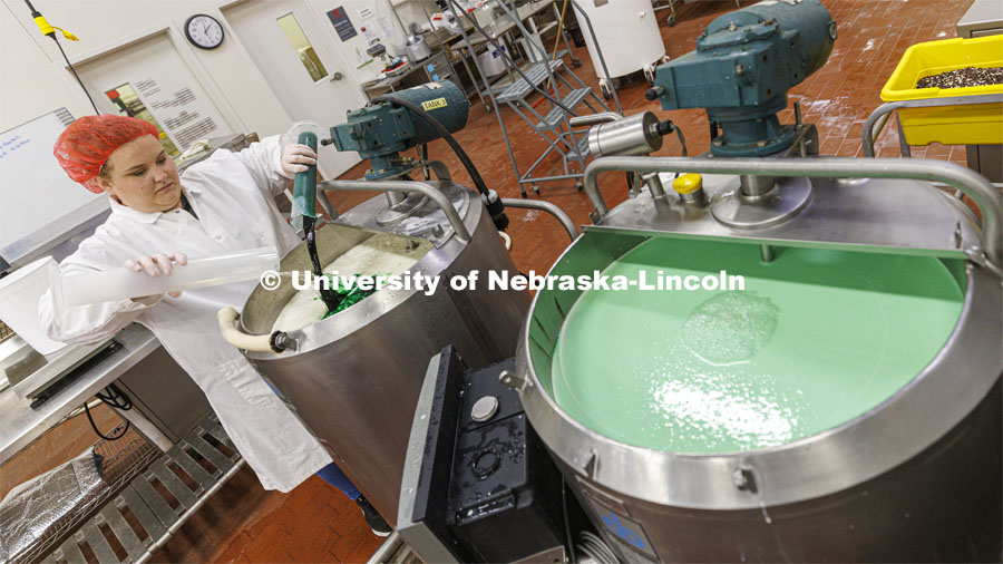 Assistant Dairy Plant Manager Mary Underwood pours in the coloring and flavor for the 100 gallons of Dairy Store 4-H Clover Mint is being made at Food Innovation Center on Nebraska Innovation Campus. July 18, 2022. Photo by Craig Chandler / University Communication.