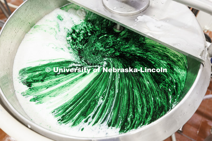 Food coloring and flavor swirl together in the mixing vat. Dairy Store 4-H Clover Mint is being made at Food Innovation Center on Nebraska Innovation Campus. July 18, 2022. Photo by Craig Chandler / University Communication.