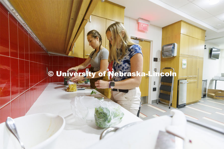 Brenna Mazour, a senior in psychology and dietetics, measures pasta as Meredith Brandt, junior in nutrition, prepares cilantro. The Rec and Wellness Center offers ready-to-go “Meal Kit Mondays” through its Wellness Kitchen on East Campus. The service offers everything needed to prepare dinner in less than an hour. July 25, 2022. Photo by Craig Chandler / University Communication.