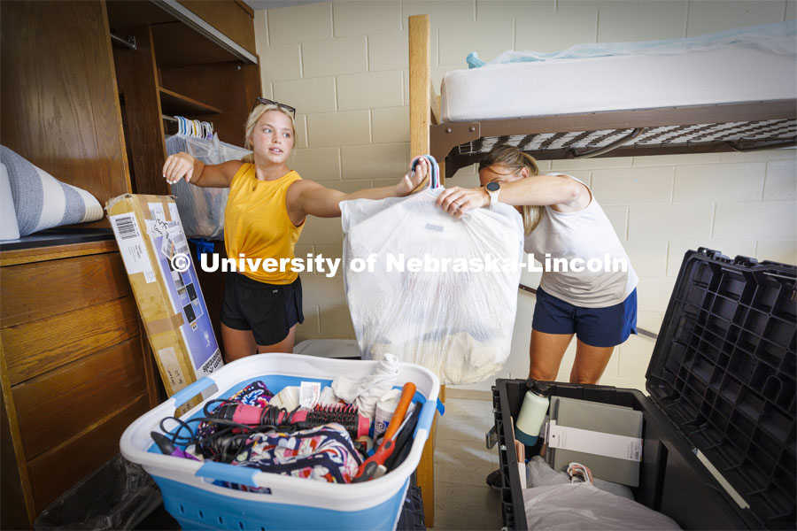 Katie Wemhoff from Grand Island grabs a handful of clothes from her mom, Cindy, as Katie unpacks her possessions. Residence Hall move in for students participating in Greek Rush. August 14, 2022. Photo by Craig Chandler / University Communication.