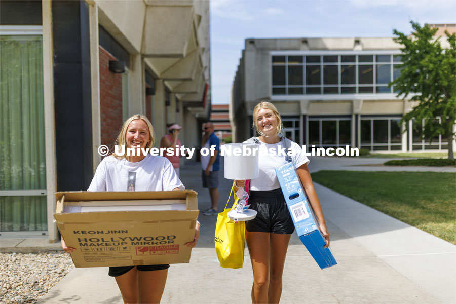 Avery Sindt, right, and her best friend, Skylar Gronewold, carry Sindt’s breakable possessions into Schramm Hall. Residence Hall move in for students participating in Greek Rush. August 14, 2022. Photo by Craig Chandler / University Communication.