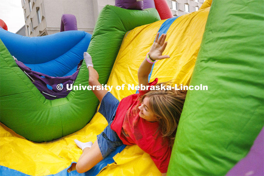 Lila Congrove, a freshman from Noblesville, Indiana, tumbles through the inflatable obstacle course at the Harper Schramm Smith residence halls block party. August 18, 2022. Photo by Craig Chandler / University Communication.