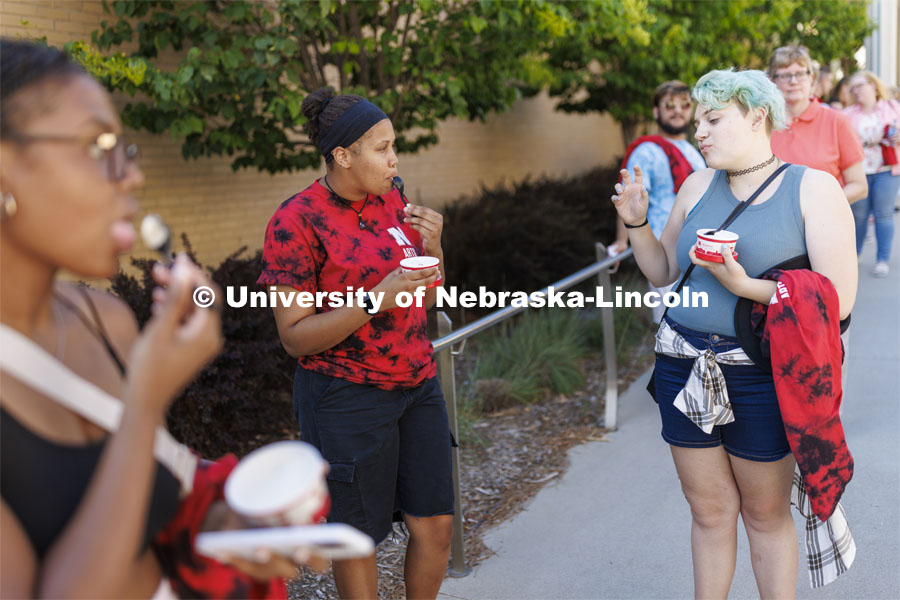Brannon Evans, a senior from Omaha, left, talks with Rain Sidwell, a freshman from Boulder, Colorado as the two eat Dairy Store ice cream while waiting in line for the food trucks. College Welcomes for new and returning students. Big Red Welcome - College Welcome Programs. August 18, 2022. Photo by Craig Chandler / University Communication.