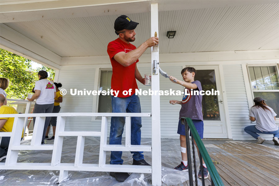 First-year law students Peter Liffrig from Bismarck North Dakota and Jude Weitzel, 8, son of new faculty member Paul Weitzel, team up to paint the porch trim. First-year law students, faculty, staff and family members come together to paint a house at 518 S. 26th Street. Photo by Craig Chandler / University Communication.