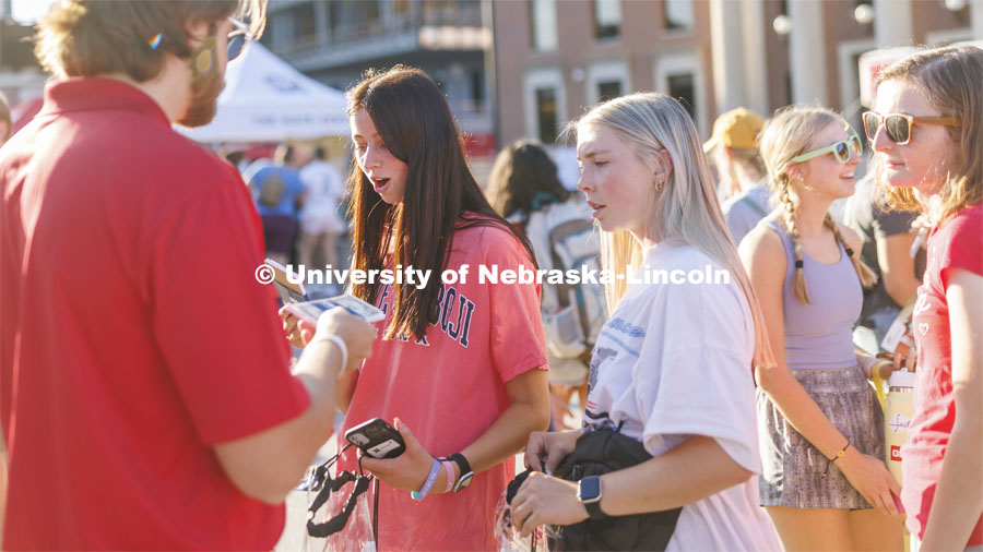 Free money is always a surprise as students received a dollar atop a notepad at the Union Bank and Trust tent. Sunday, the Street Fest filled the parking lot by East Stadium with hundreds of booths hosted by local businesses, nonprofit organizations, UNL departments and plenty of music, free food, giveaways and prizes. August 21, 2022. Photo by Craig Chandler / University Communication.