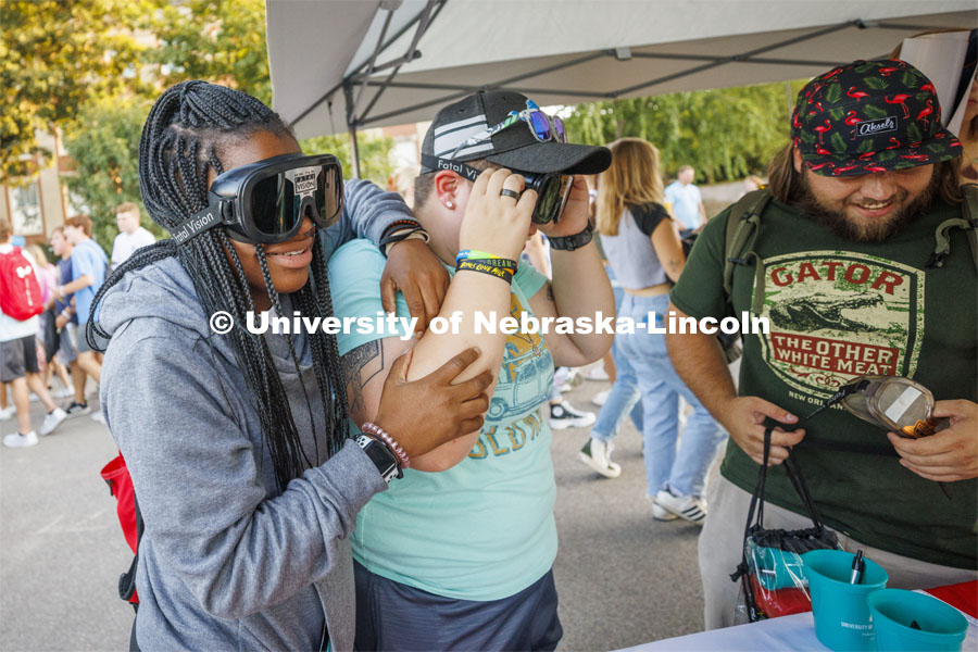 Nicole Sanders, a freshman from Virginia, leans on her friend, Jaylee Bonta, a freshman from North Platte, at the UNL Police Department booth as the two try out the goggles which simulate being under the influence. Sunday, the Street Fest filled the parking lot by East Stadium with hundreds of booths hosted by local businesses, nonprofit organizations, UNL departments and plenty of music, free food, giveaways and prizes. August 21, 2022. Photo by Craig Chandler / University Communication.