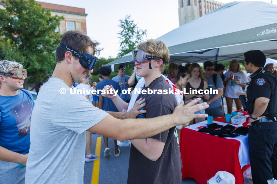 Maxwell Hamill, a freshman from Sheldon, Iowa, and Gavin O’Donnell, a freshman from Geneva, Illinois, bump into each other at the UNL Police Department booth as the two try out the goggles which simulate being under the influence. Sunday, the Street Fest filled the parking lot by East Stadium with hundreds of booths hosted by local businesses, nonprofit organizations, UNL departments and plenty of music, free food, giveaways and prizes. August 21, 2022. Photo by Craig Chandler / University Communication.