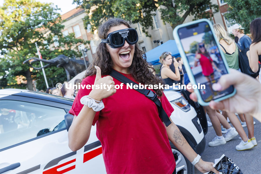 Grace Carey, a junior from Bellevue, Nebraska, has her photo taken by a friend as she wears goggles which simulate being under the influence. Sunday, the Street Fest filled the parking lot by East Stadium with hundreds of booths hosted by local businesses, nonprofit organizations, UNL departments and plenty of music, free food, giveaways and prizes. August 21, 2022. Photo by Craig Chandler / University Communication.