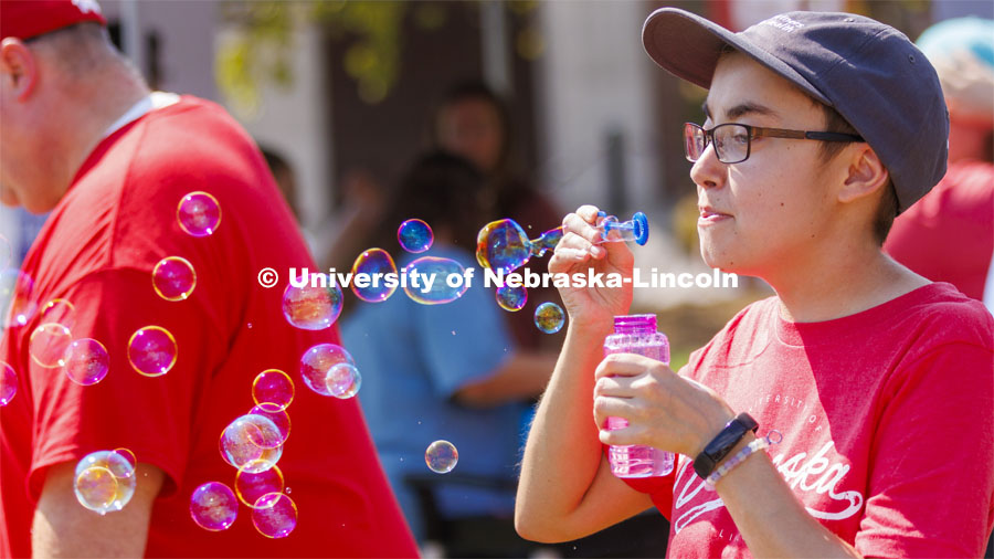 Sarah Roscoe blows bubbles at the UNL Christian Graduate Student club table. Club Fair in the green space by the Nebraska Union at City Campus. More than 120 recognized student organizations (RSOs) to join for social, professional and leadership interests. RSO members and officers will be on hand to provide details about their organization and answer questions from prospective new members. August 24, 2022. Photo by Craig Chandler / University Communication.