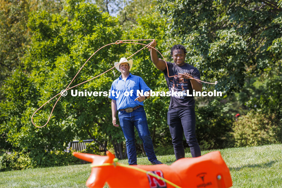Jerran Henry, a sophomore, tries his hand at roping as Rodeo Club coach Marshal Peterson watches. Club Fair in the green space by the Nebraska Union at City Campus. More than 120 recognized student organizations (RSOs) to join for social, professional and leadership interests. RSO members and officers will be on hand to provide details about their organization and answer questions from prospective new members. August 24, 2022. Photo by Craig Chandler / University Communication.