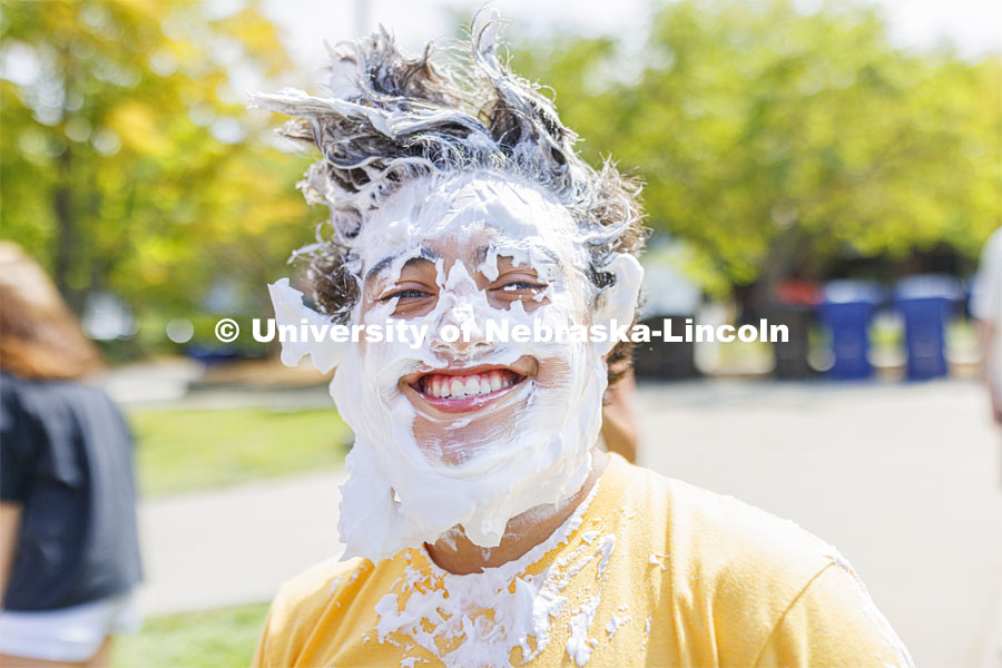 Quinton Chavez smiles after taking a pie to the face as he and Acacia Fraternity brothers raise money for Bryan Health. Acacia fraternity held a pie-in-the-face fundraiser for Bryan Health’s new cancer center. All the UNL fraternities are participating and have raised more than $200,000 so far this year. August 25, 2022. Photo by Craig Chandler / University Communication.