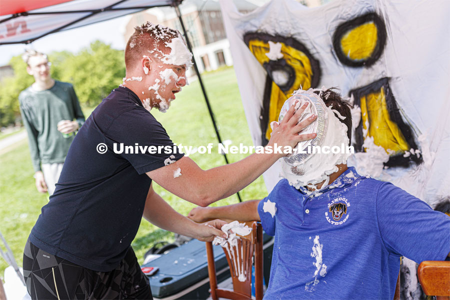 Jonathan Logan plants a pie on the face of Jarrett Michie as they raise money for Bryan Health. Acacia fraternity held a pie-in-the-face fundraiser for Bryan Health’s new cancer center. All the UNL fraternities are participating and have raised more than $200,000 so far this year. August 25, 2022. Photo by Craig Chandler / University Communication.