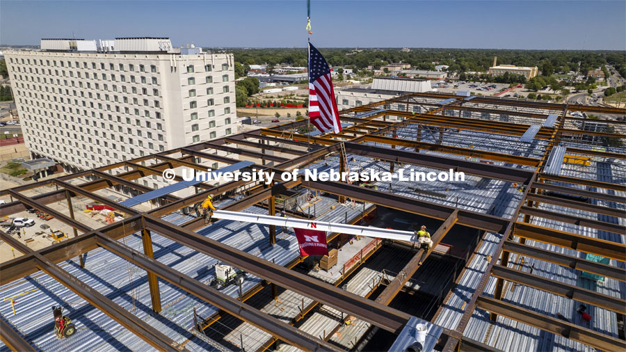 Steel workers move the final beam into place during a construction celebration on Aug. 31. The event signaled the end of steel framing for the $115 million Kiewit Hall build. Kiewit Hall topping off ceremony. August 31, 2022. Photo by Craig Chandler / University Communication.