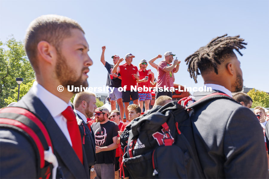 Students stand on the hood of the Bone Yard Bus and cheer as the Huskers walk through the crowd. Student Tailgate and Unity Walk in the Union green space before the game. NU vs. North Dakota. September 3, 2022. Photo by Craig Chandler / University Communication.