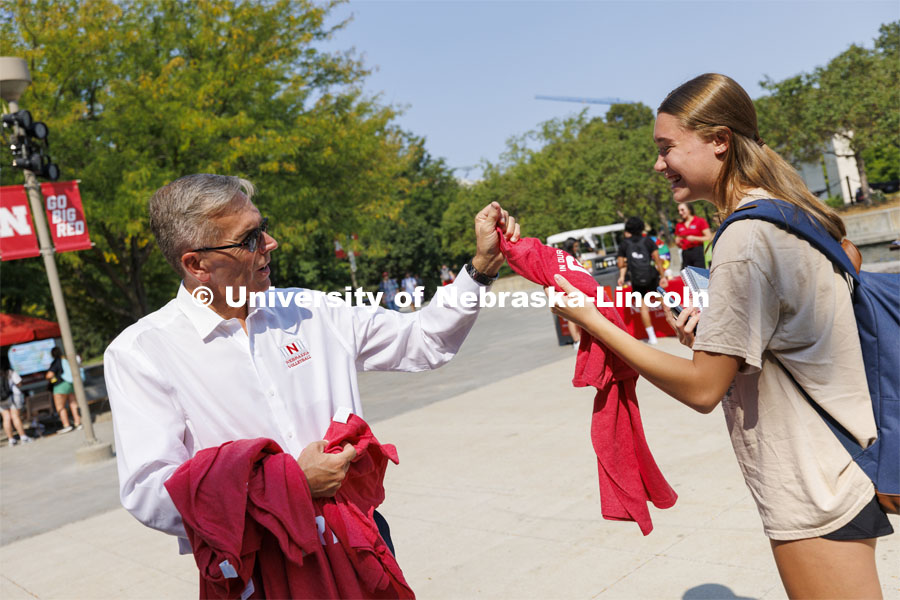Grace Besse, a freshman from South Bend, Indiana, receives a shirt as Chancellor Ronnie Green hands out Grit and Glory t-shirts at the Nebraska Union Plaza. September 7, 2022. Photo by Craig Chandler / University Communication.