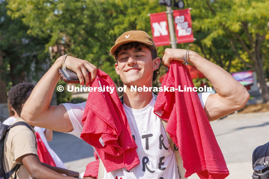 Peyton Vinckier, a freshman from Ashland, Nebraska, shows off his shirts he received. Chancellor Ronnie Green hands out Grit and Glory t-shirts at the Nebraska Union Plaza. September 7, 2022. Photo by Craig Chandler / University Communication.