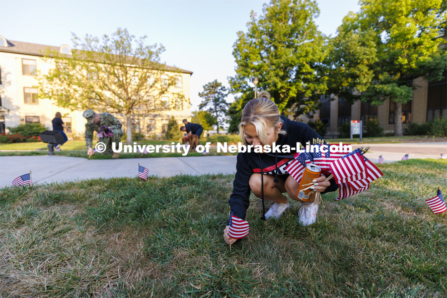 ASUN member Aleks Glowik places a flag on East Campus. The Nebraska Military and Veteran Success Center, ASUN and others placed flags and signs on East Campus today to commemorate 9/11. The display will be moved to city campus on Monday. September 9, 2022. Photo by Craig Chandler / University Communication.