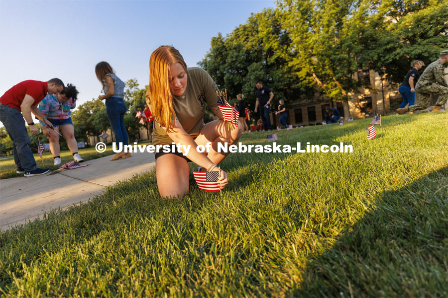 Rianna Wells, a sophomore from Ft. Calhoun, Nebraska and a member of the Army ROTC, places a flag Friday morning. The Nebraska Military and Veteran Success Center, ASUN and others placed flags and signs on East Campus today to commemorate 9/11. The display will be moved to city campus on Monday. September 9, 2022. Photo by Craig Chandler / University Communication.