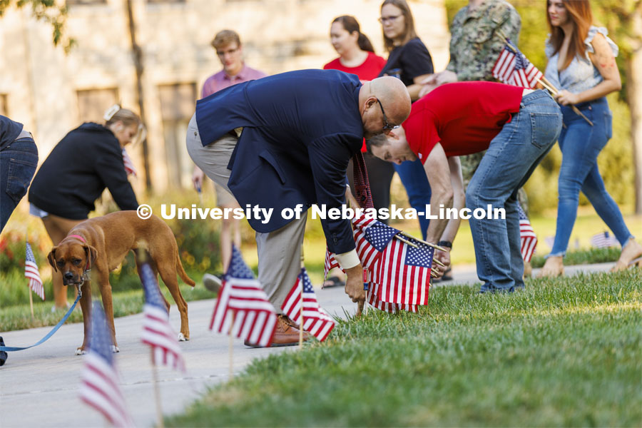 IANR Vice Chancellor and Navy veteran Michael Boehm places a flag on East Campus Friday morning to commemorate Patriot Day. The Nebraska Military and Veteran Success Center, ASUN and others placed flags and signs on East Campus today to commemorate 9/11. The display will be moved to city campus on Monday. September 9, 2022. Photo by Craig Chandler / University Communication.