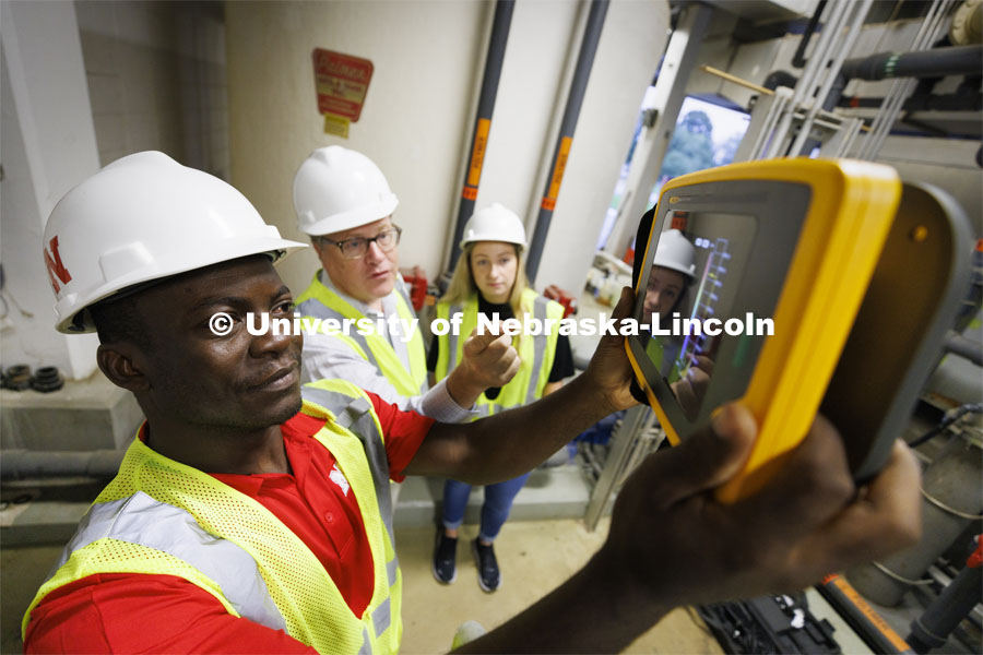 Bruce Dvorak, center, Professor of Civil and Environmental Engineering, coaches Yves Cedric Tamwo Noubissi, left, senior in Mechanical Engineering, and Sussan Moussavi, graduate student in Civil Engineering, in the use of a Fluke Precision Acoustic Imager used to detect leaks of gases and vacuum from pipes and tanks. They are working inside Lincoln’s Theresa Street Wastewater Treatment Plant. September 23, 2022. Photo by Craig Chandler / University Communication.