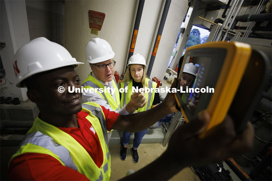 Bruce Dvorak, center, Professor of Civil and Environmental Engineering, coaches Yves Cedric Tamwo Noubissi, left, senior in Mechanical Engineering, and Sussan Moussavi, graduate student in Civil Engineering, in the use of a Fluke Precision Acoustic Imager used to detect leaks of gases and vacuum from pipes and tanks. They are working inside Lincoln’s Theresa Street Wastewater Treatment Plant. September 23, 2022. Photo by Craig Chandler / University Communication.