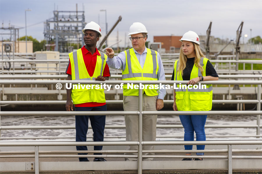 Bruce Dvorak, center, Professor of Civil and Environmental Engineering, discusses the sedimentation tanks with Yves Cedric Tamwo Noubissi, left, senior in Mechanical Engineering, center and Sussan Moussavi, graduate student in Civil Engineering at Lincoln’s Wastewater Treatment Plant northeast of Innovation Campus. September 23, 2022. Photo by Craig Chandler / University Communication.