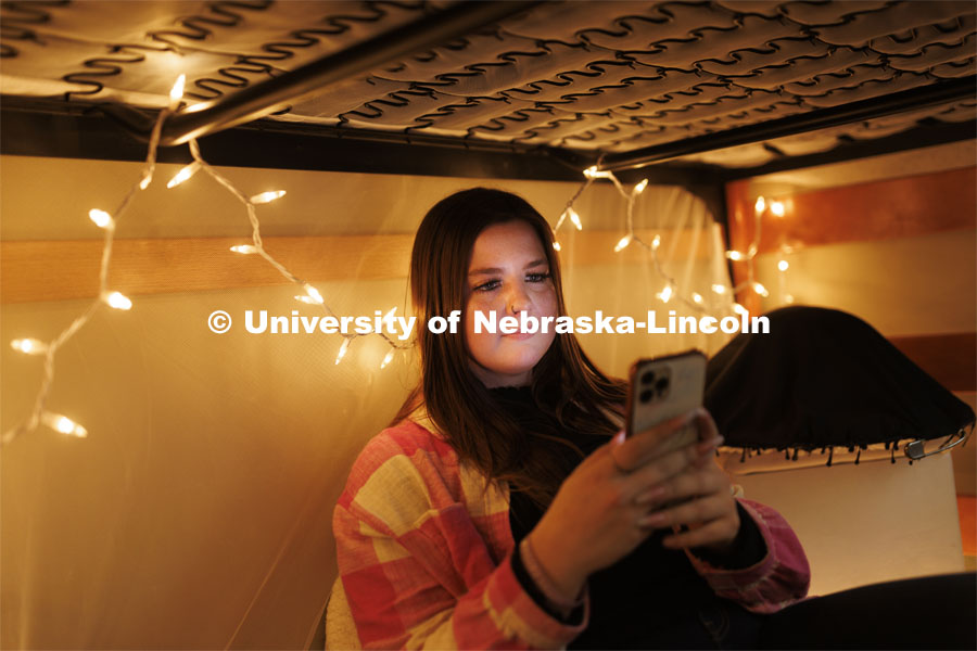 A student takes a selfie under her bunkbed in her Couryard Residence Hall room. Housing Photo Shoot in The Courtyards Residence Hall. September 27, 2022. Photo by Craig Chandler / University Communication.