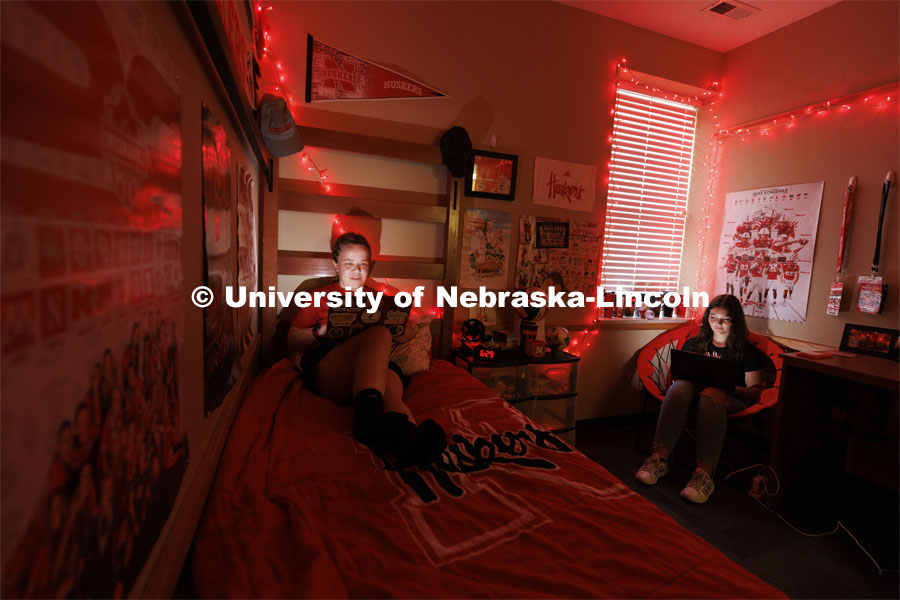Students studying by the glow of red christmas lights in a University Suites Residence Hall room. Housing Photo Shoot in University Suites Residence Hall. September 27, 2022. Photo by Craig Chandler / University Communication.