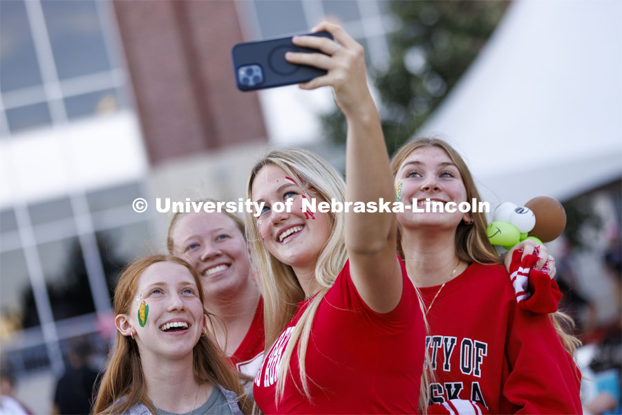 Students pose for a selfie at the Homecoming Parade and Cornstalk. September 30, 2022. Photo by Craig Chandler / University Communication.