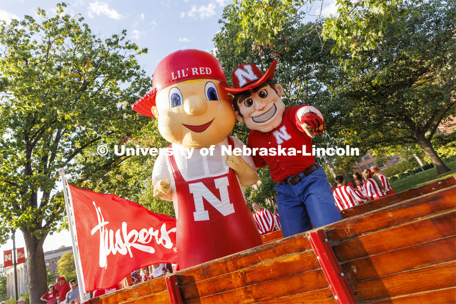 Herbie Husker and Lil’ Red in a trailer pulled by Jake Jundt a former Husker Cheer squad member and current assistant with the team. Jundt pulled the trailer with an antique International Harvester tractor his family owns. Homecoming Parade and Cornstalk. September 30, 2022. Photo by Craig Chandler / University Communication.