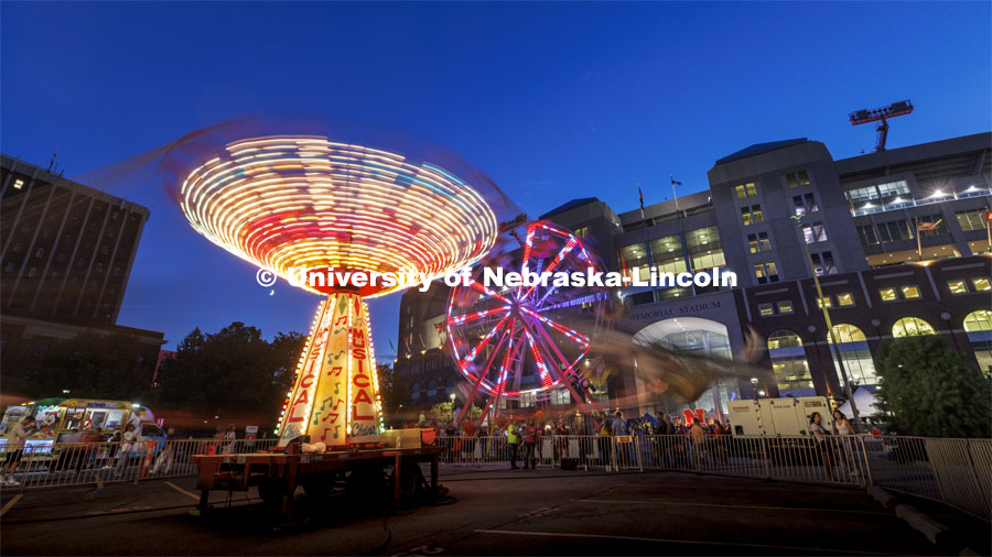 The Musical Chairs ride and the Ferris Wheel were spinning in a long exposure after the sun set Friday night. Homecoming Parade and Cornstalk. September 30, 2022. Photo by Craig Chandler / University Communication.