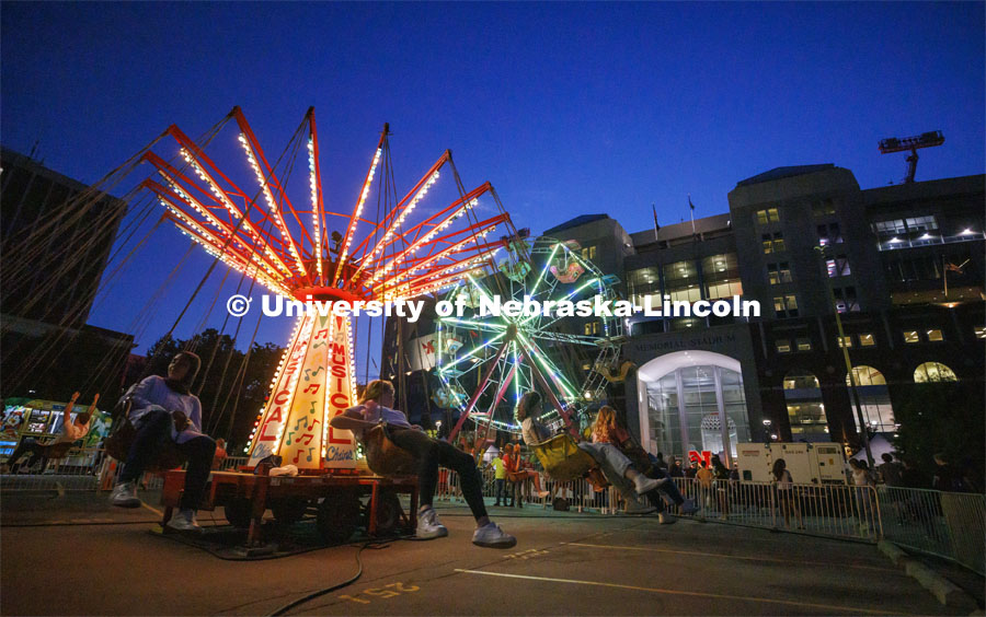 The Musical Chairs ride and the Ferris Wheel lighted up the east stadium parking lot Friday night. Homecoming Parade and Cornstalk. September 30, 2022. Photo by Craig Chandler / University Communication.