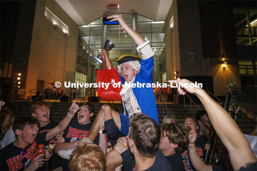 Aidan Bakke, a freshman in business administration, is lifted up by his Sigma Chi fraternity brothers as they celebrate his Jester win. Homecoming Parade and Cornstalk. September 30, 2022. Photo by Craig Chandler / University Communication.