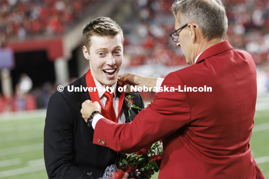 Newly crowned homecoming royalty Jacob Drake has a medallion placed over his head by Chancellor Ronnie Green. Nebraska vs. Indiana football Homecoming game. October 1, 2022. Photo by Craig Chandler / University Communication.