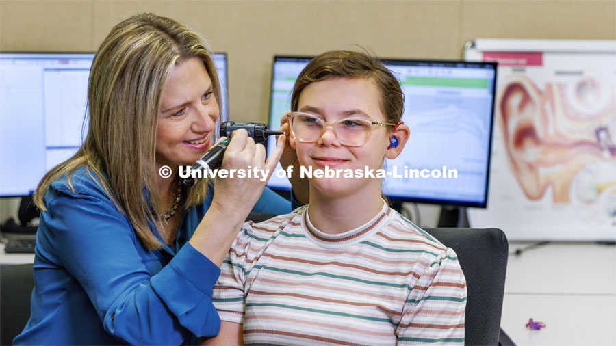 Audiologist Stacie Ray checks the ears and hearing aids of 13-year-old Chloie Lechance in the Barkley Clinic. October 21, 2022. Photo by Craig Chandler / University Communication.