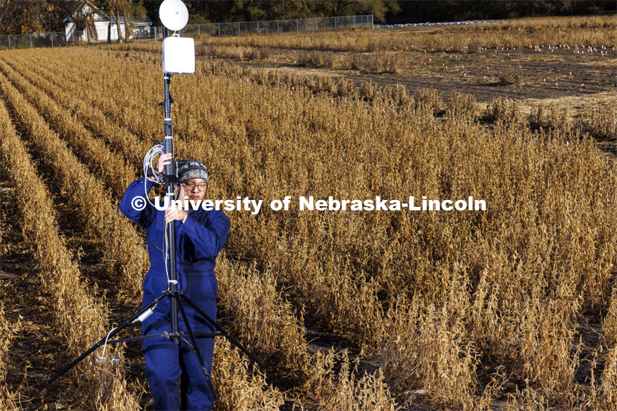 Graduate students Sang Won Shin carries a millimeter-wave (mmWave) radio with phased-array antenna out of a soybean field on east campus field. October 28, 2022. Photo by Craig Chandler / University Communication.