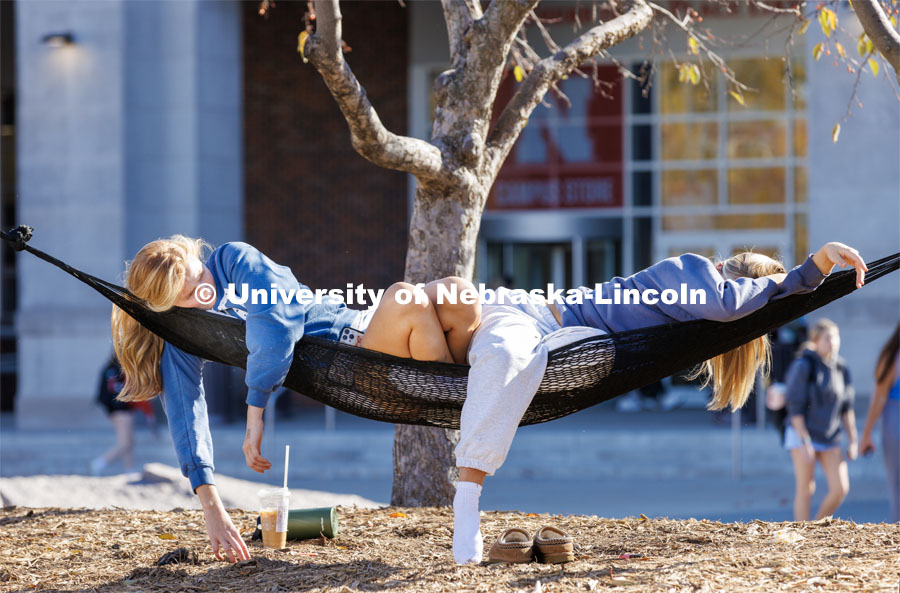Camille Smith and Carly Tapson lounge in the hammocks outside the Nebraska Union on an unseasonably warm first day of November. November 1, 2022. Photo by Craig Chandler / University Communication.