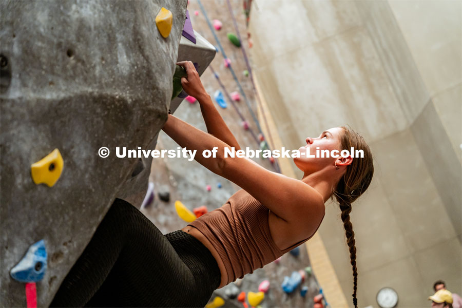 Katharine Wadas, sophomore, climbing a boulder route during the League of Extraordinary Boulderers. League of Extraordinary Boulderers scale the climbing wall at Campus Recreation’s Outdoor Adventure Center. November 3, 2022. Photo by Jonah Tran / University Communication.
