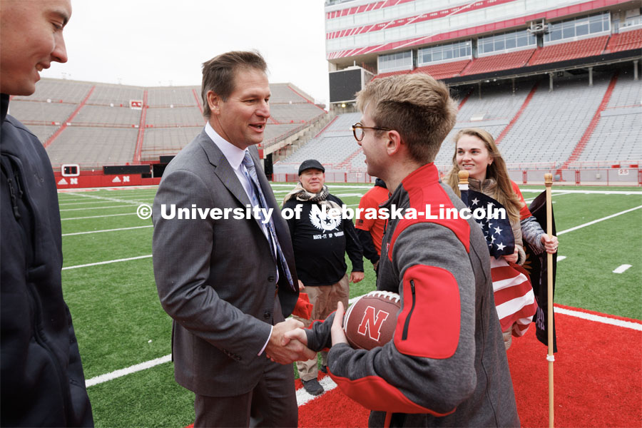 Nebraska Athletic Director Trev Alberts shakes hands with Ruck March organizer Everett Bloom after presenting the game ball to the Ruck Marchers which will be walked to the Iowa game. November 15, 2022. Photo by Craig Chandler / University Communication.